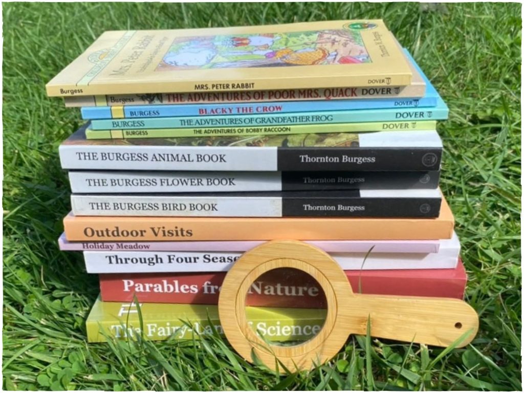 A stack of nature living books outside in the grass